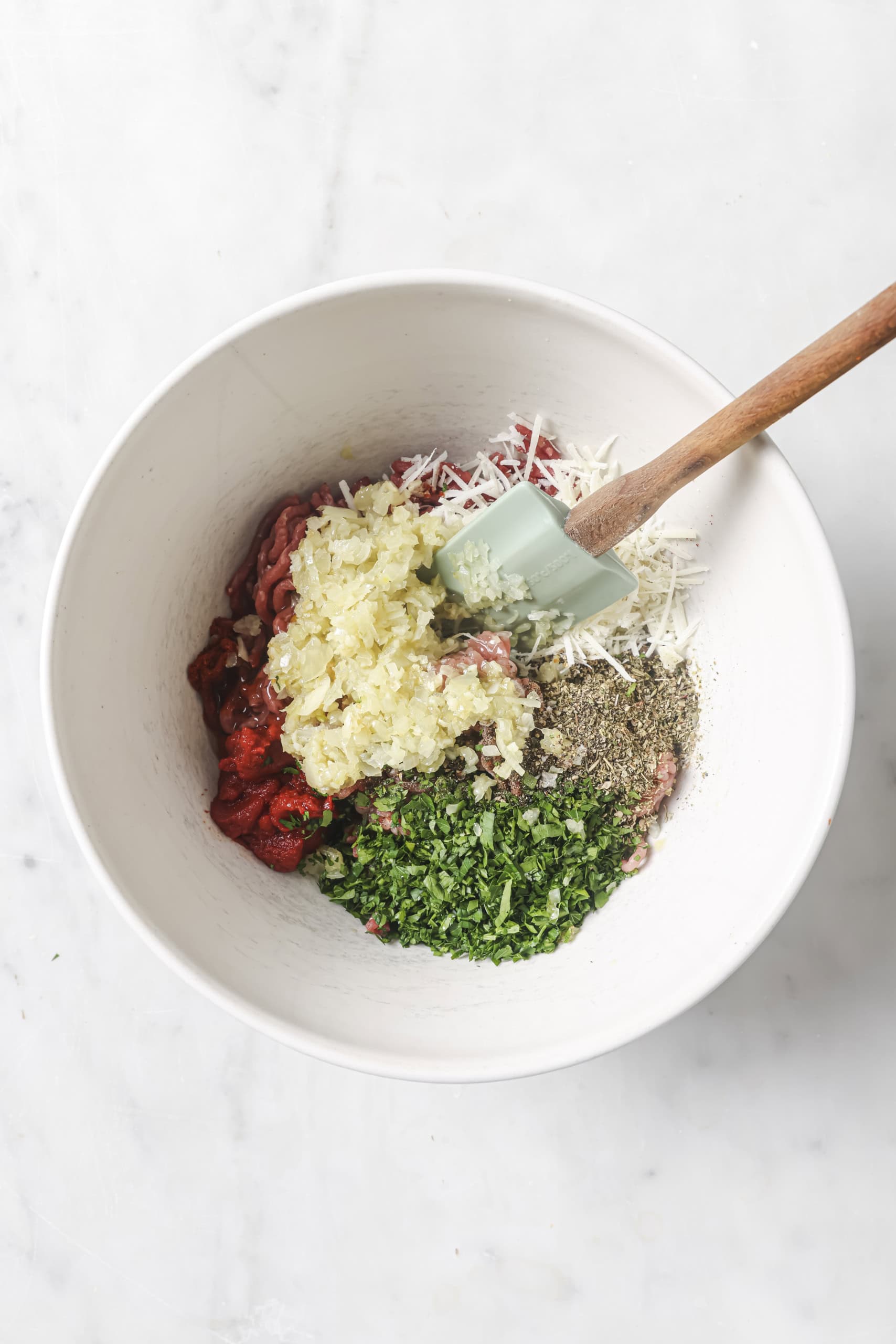 ingredients for meatballs in a bowl with a spatula