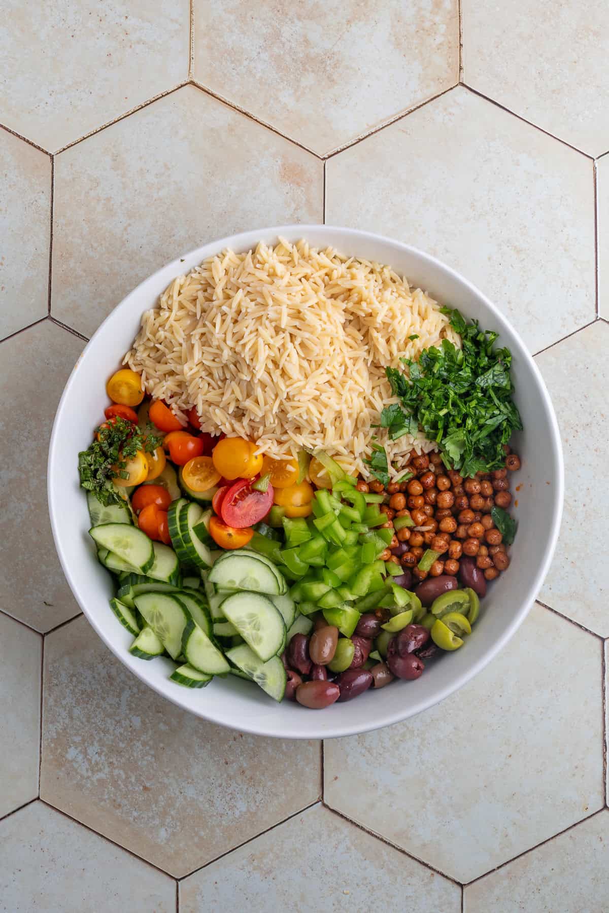 ingredients for orzo salad in a bit white bowl