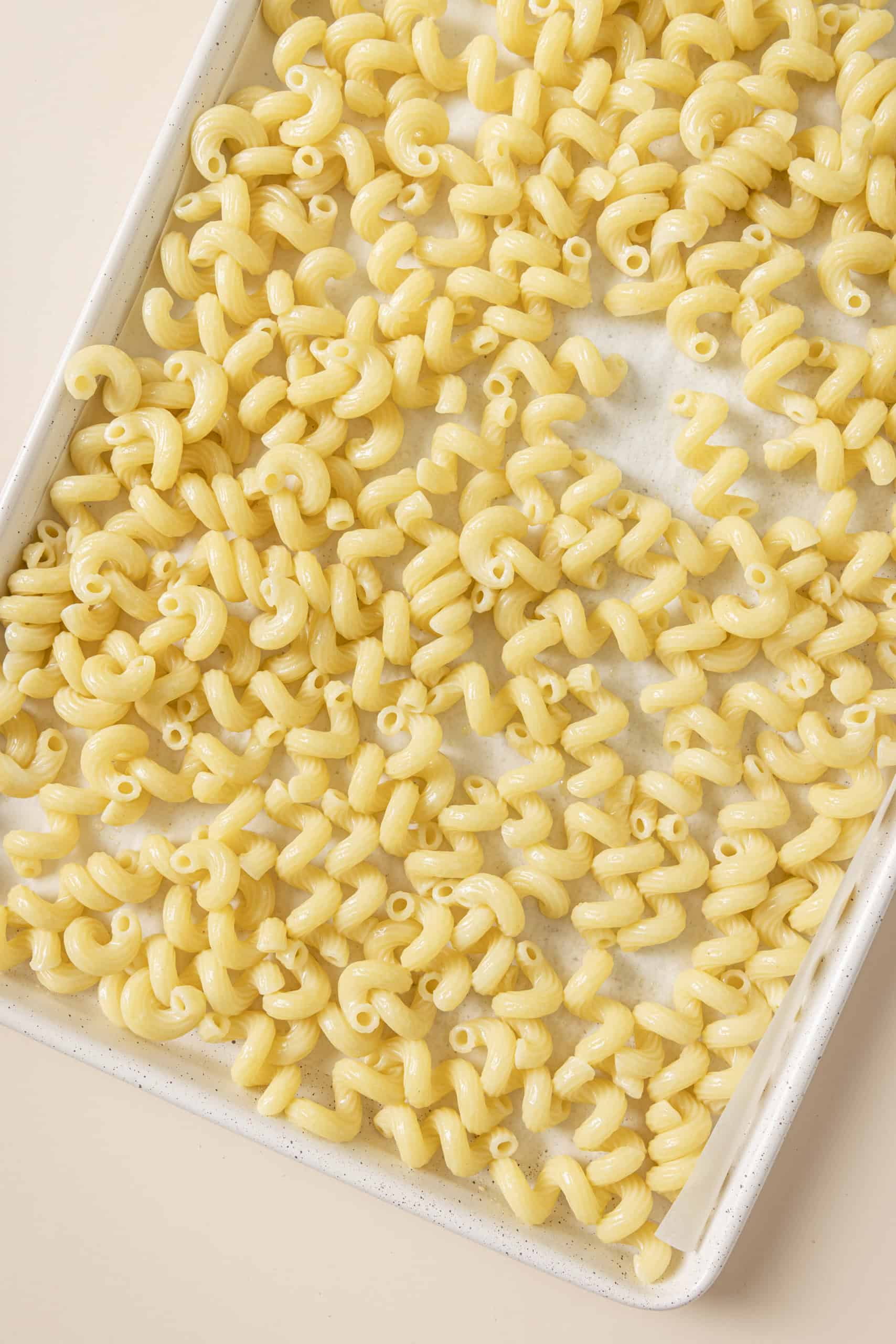 cooling pasta on a cookie sheet