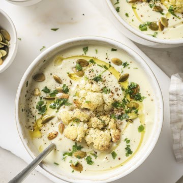 roasted cauliflower soup in a bowl with garnishes