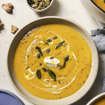 Creamy pumpkin butternut squash soup with seeds and herbs, perfect for seasonal cravings.
