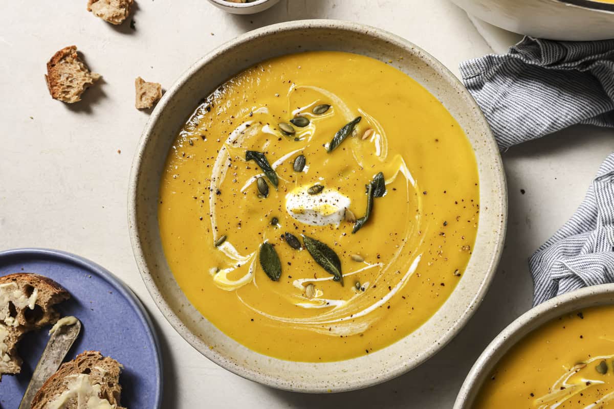 Creamy butternut squash  soup with toasted pumpkin seeds, sour cream, and herbs for cozy fall comfort.