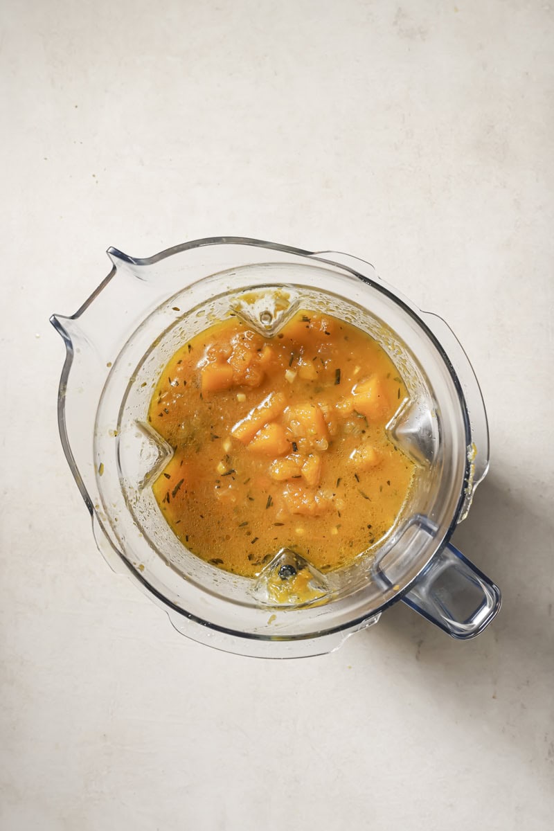 Creamy butternut squash soup in a blender for cozy fall recipes.