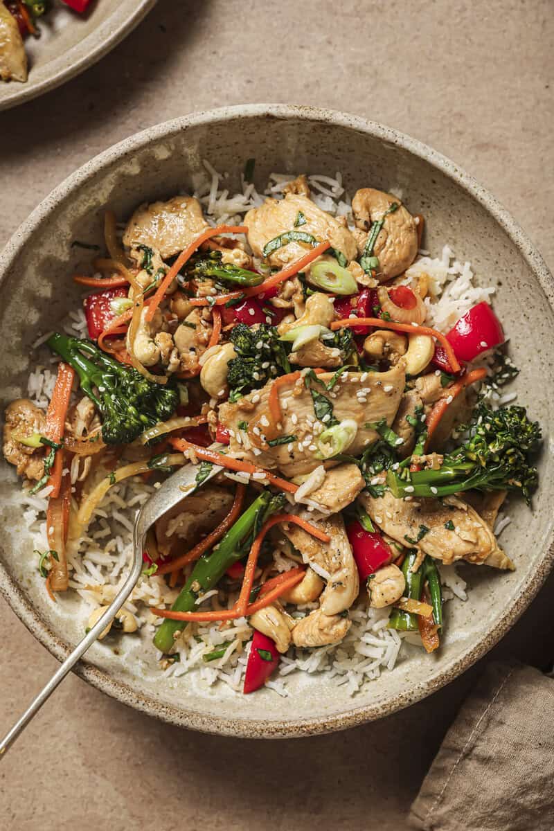 chicken stir fry in a bowl with chopsticks