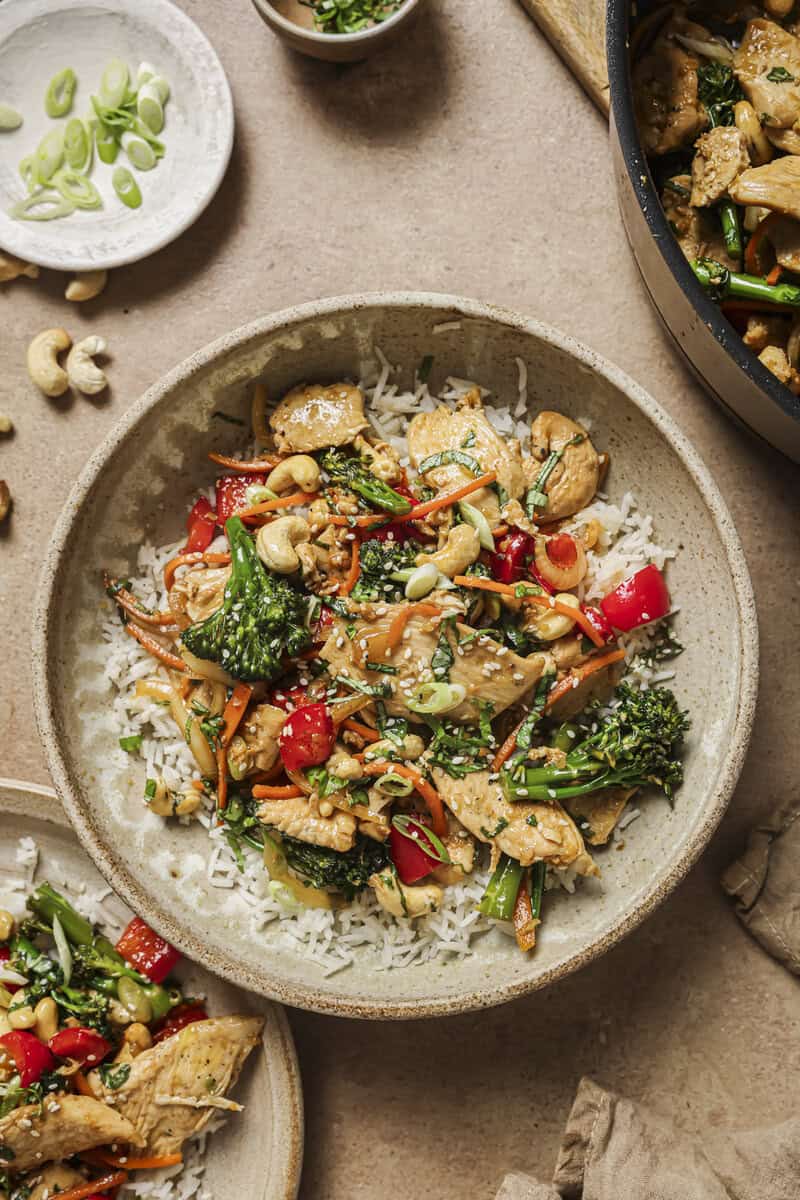 basil cashew chicken stir fry in a. bowl with toppings