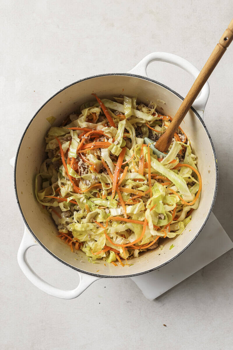 cabbage added to dutch oven with carrots for egg roll soup