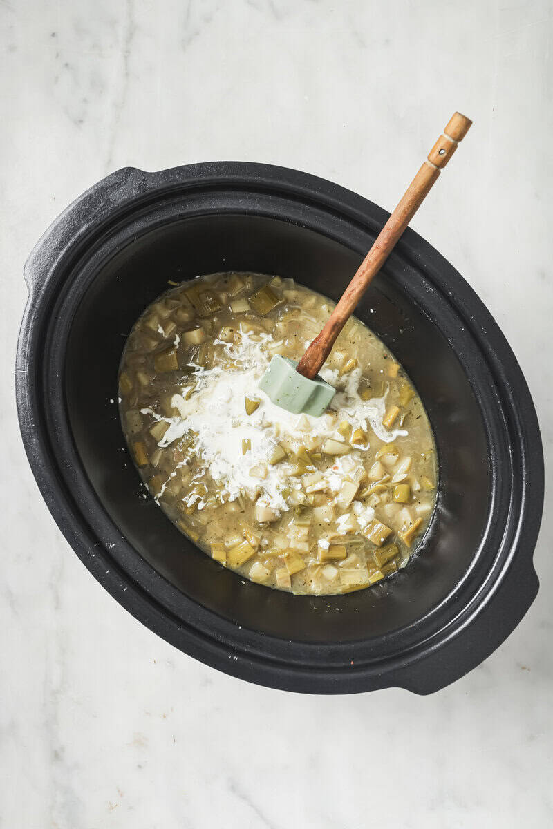 cream going into the crock pot with the potato soup