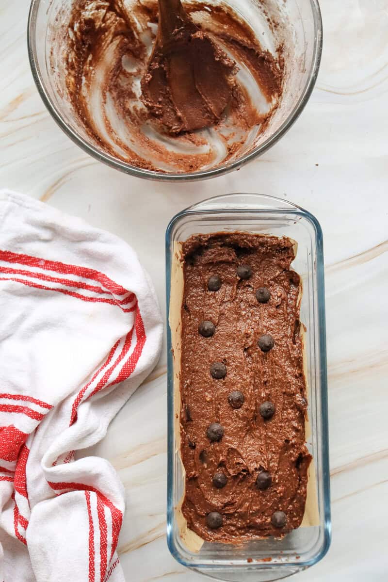 chocolate loaf cake  in a loaf pan with chocolate chips on top