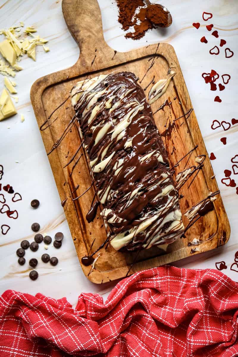 chocolate loaf cake on a cutting board with icing