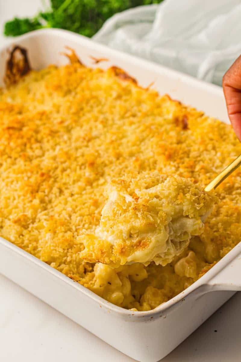 mac and cheese in a casserole dish with spoon