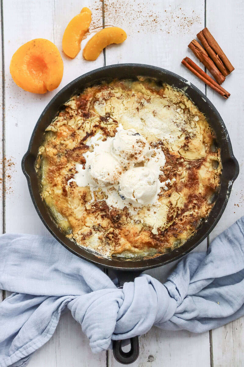skillet peach dump cake in cast iron with ice cream