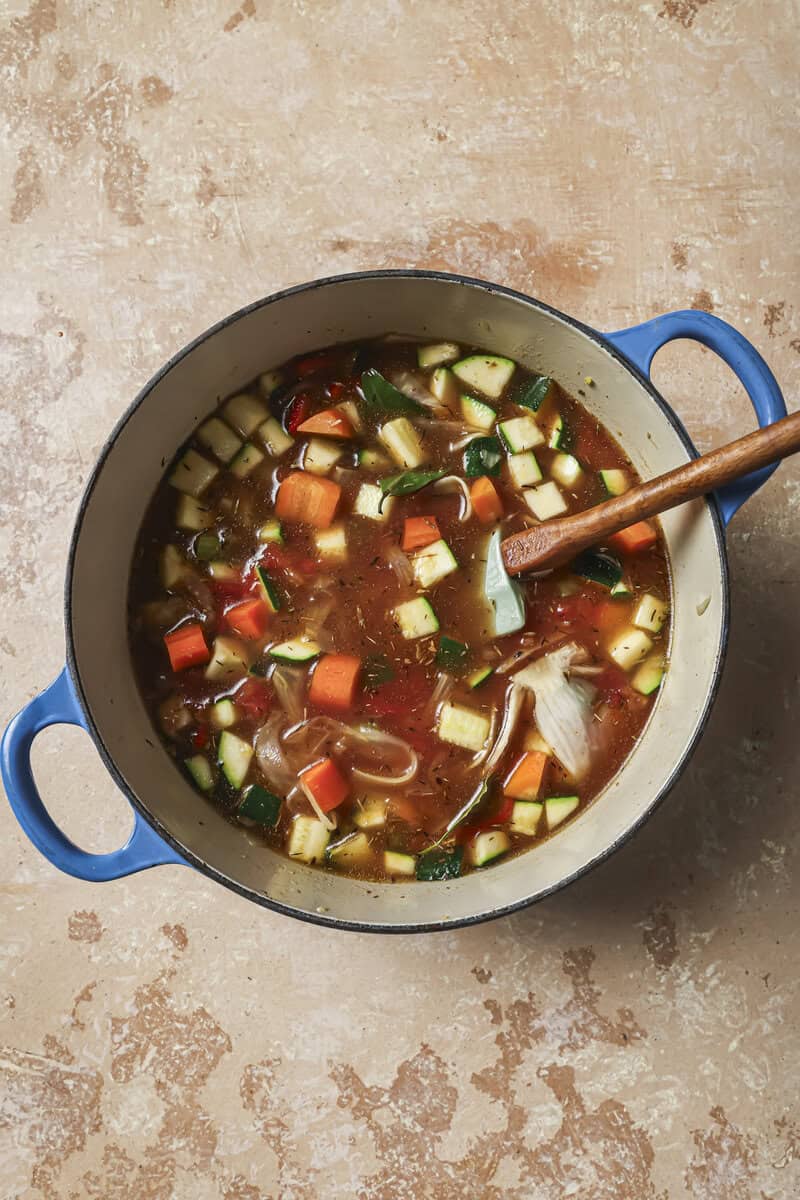 broth added to vegetable mixture in pot