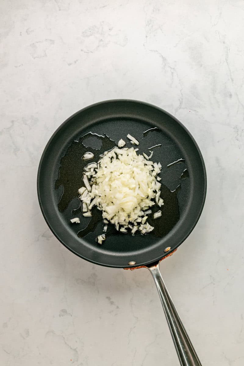 diced onions sauteing in pan with oil