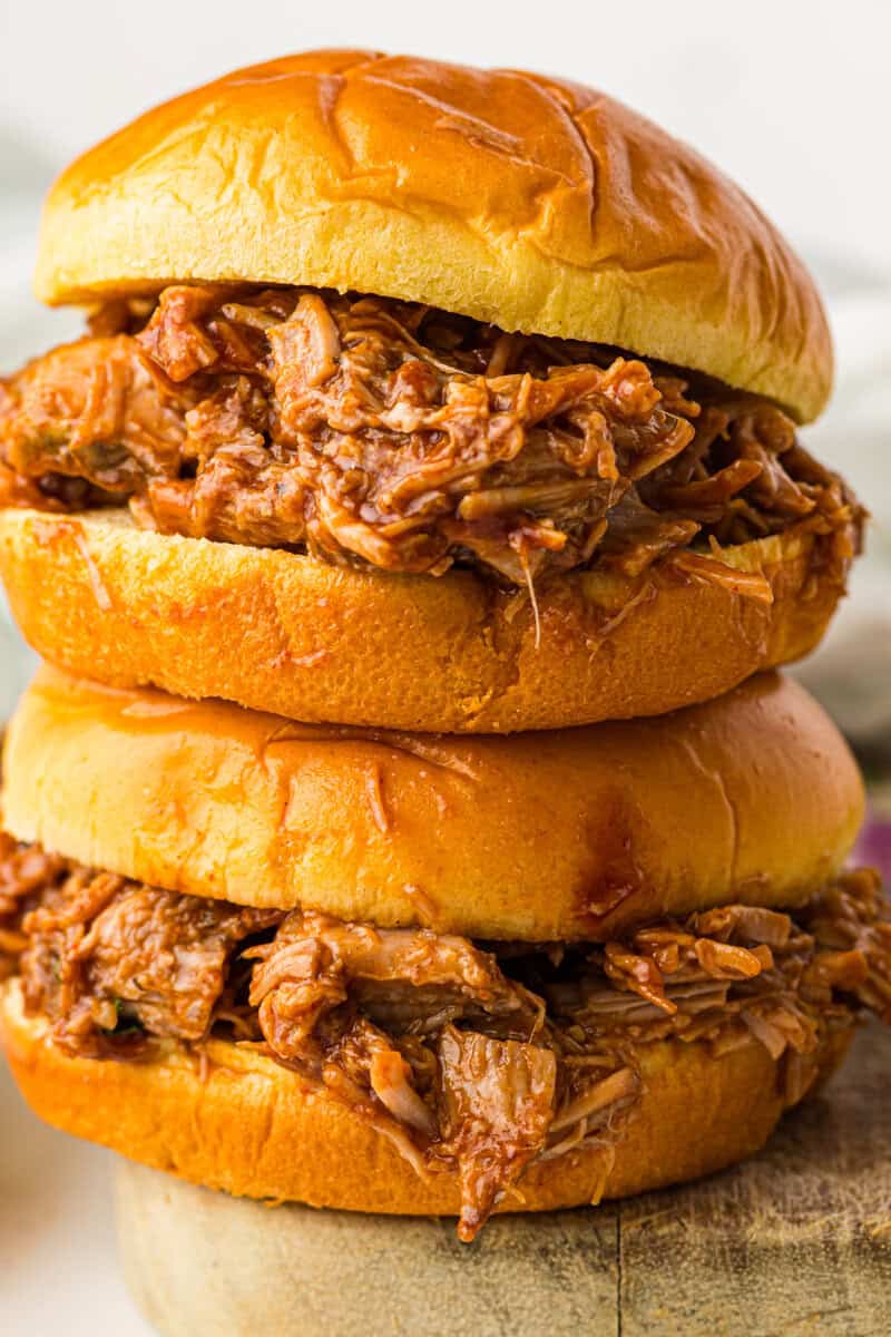 two slow cooker barbecue pulled pork sandwiches on brioche bun