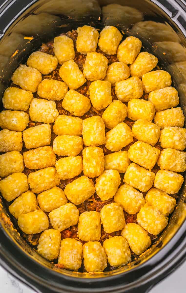 tater tots added on top of the Slow Cooker Chili Cheese Tatertot Casserole 