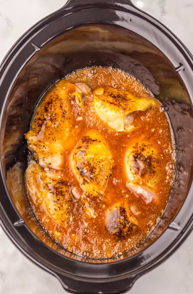 cooked chicken thighs with sauce in a crockpot