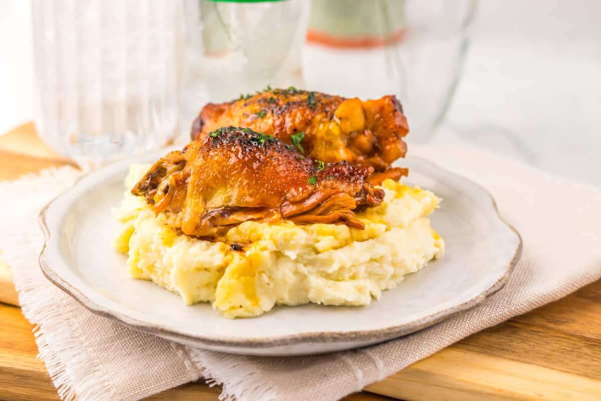slow cooker chicken thighs on a plate with mashed potatoes