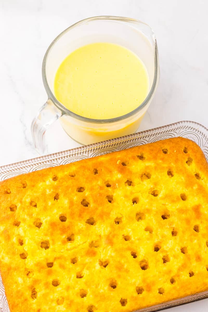 yellow cake in a pan with holes poked in