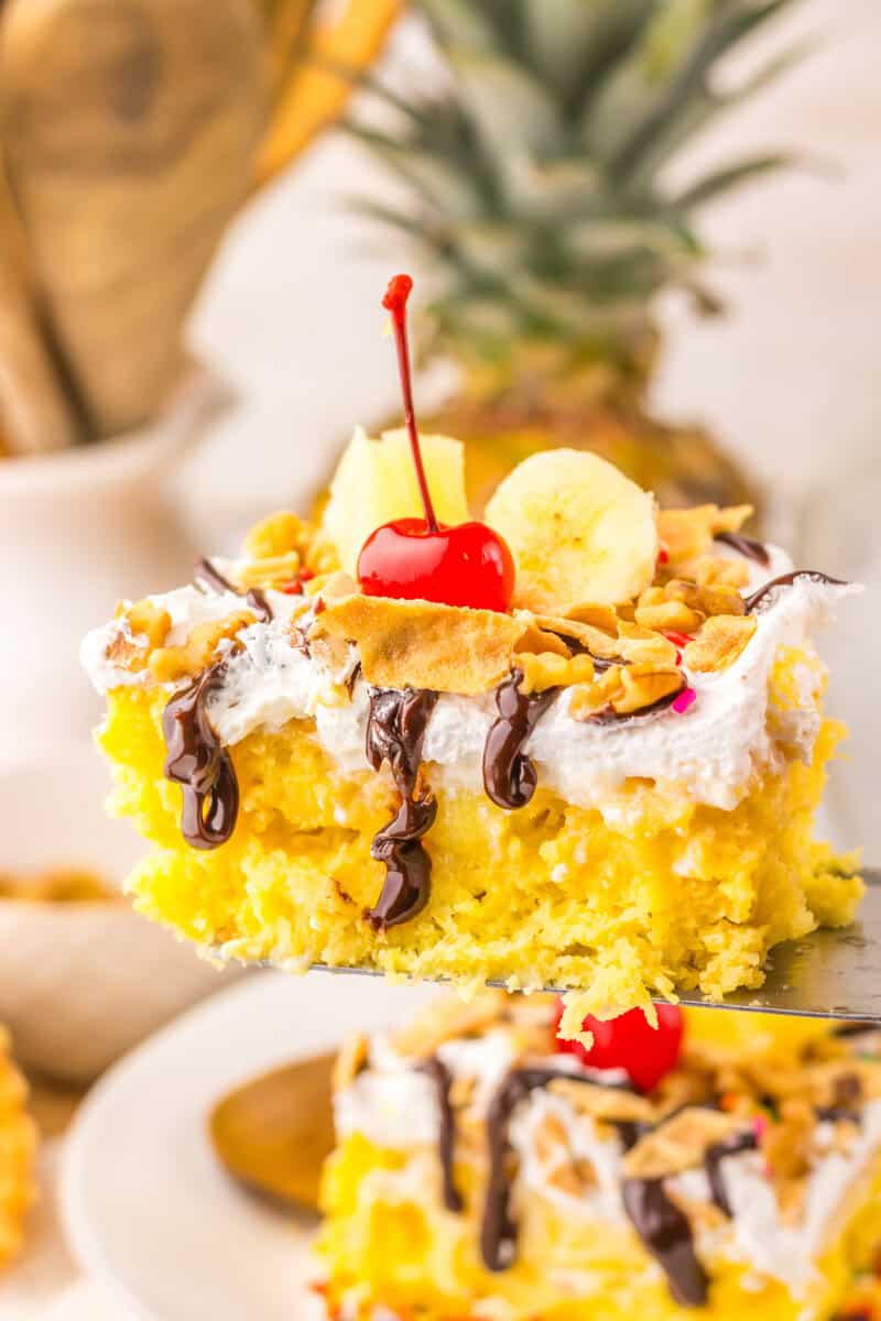 piece of banana split poke cake on a spatula
