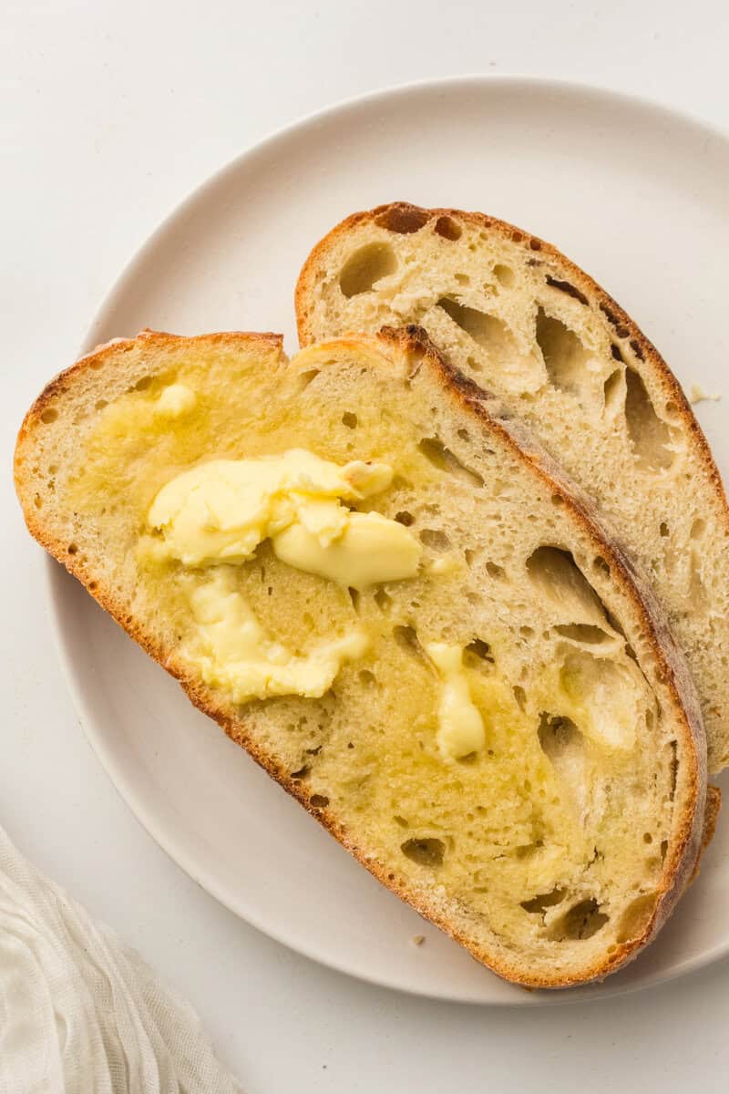 sliced warm sourdough bread with butter