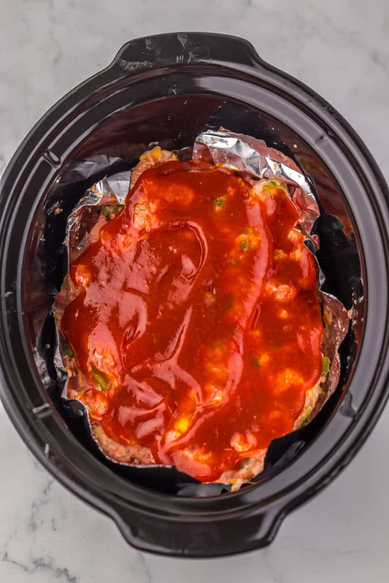 meatloaf covered in ketchup in the slow cooker