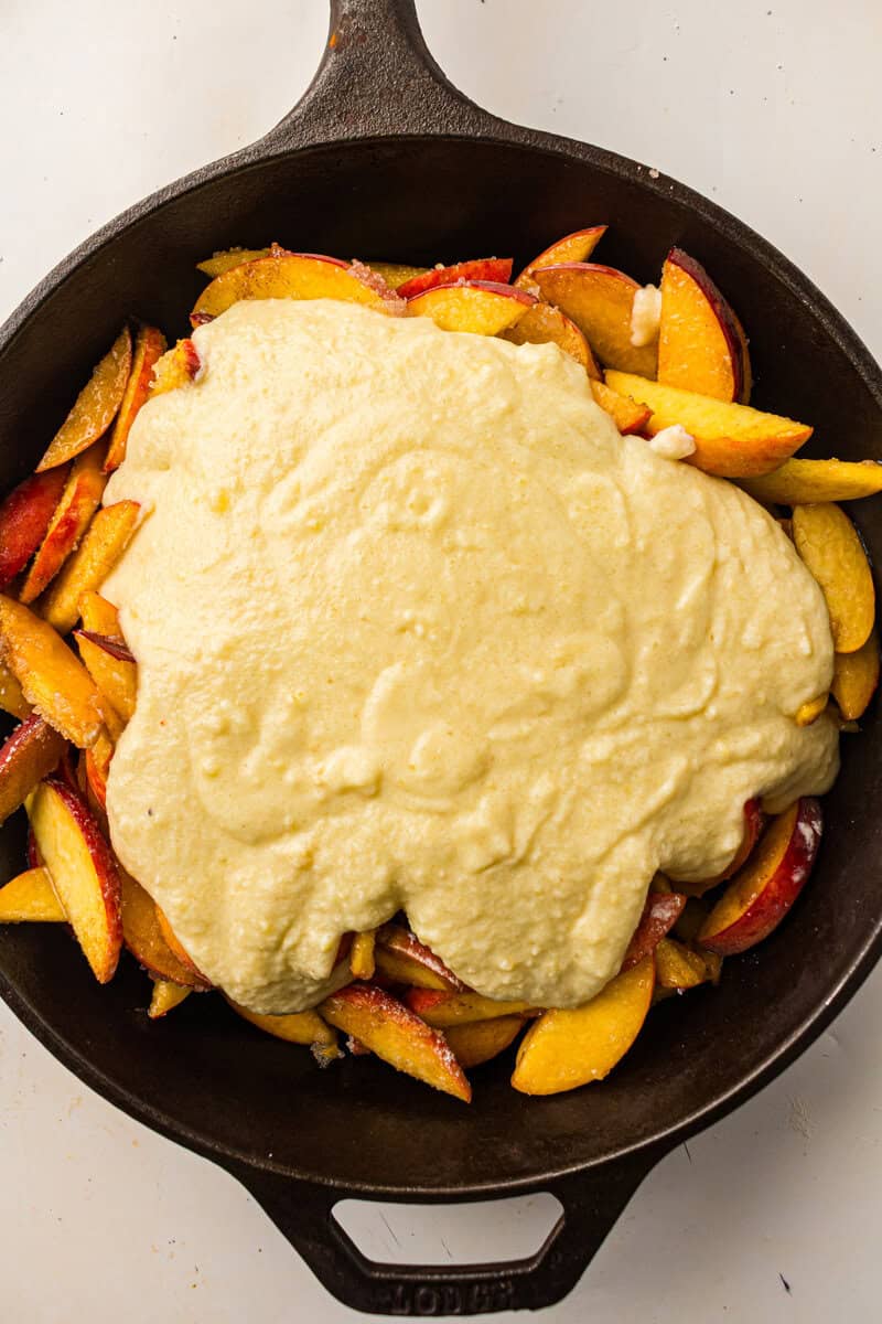 topping on top of peach slices in cast iron pan