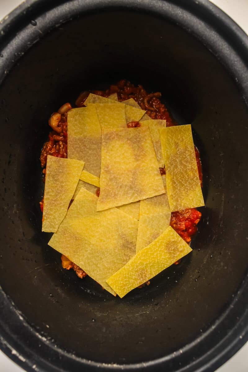 layer of pasta on top of meat sauce