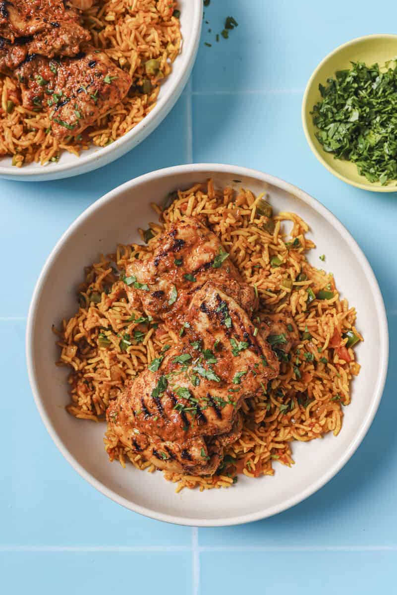 nandos chicken thighs with rice on a a plate