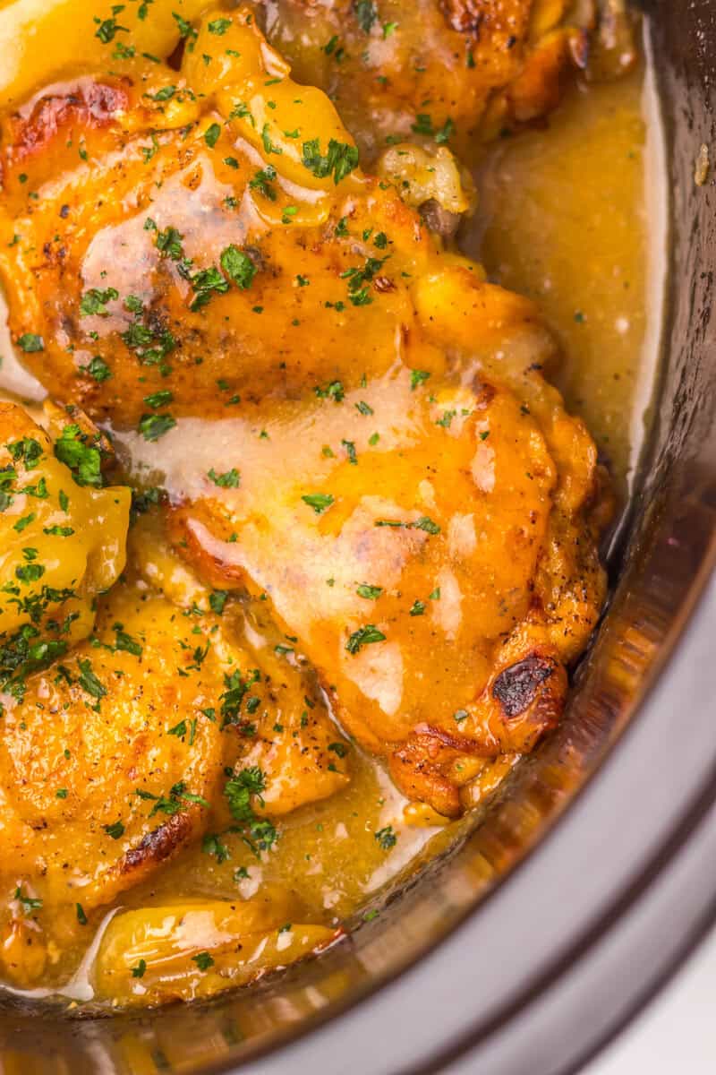 Chicken in a slow cooker covered in a thick sauce.