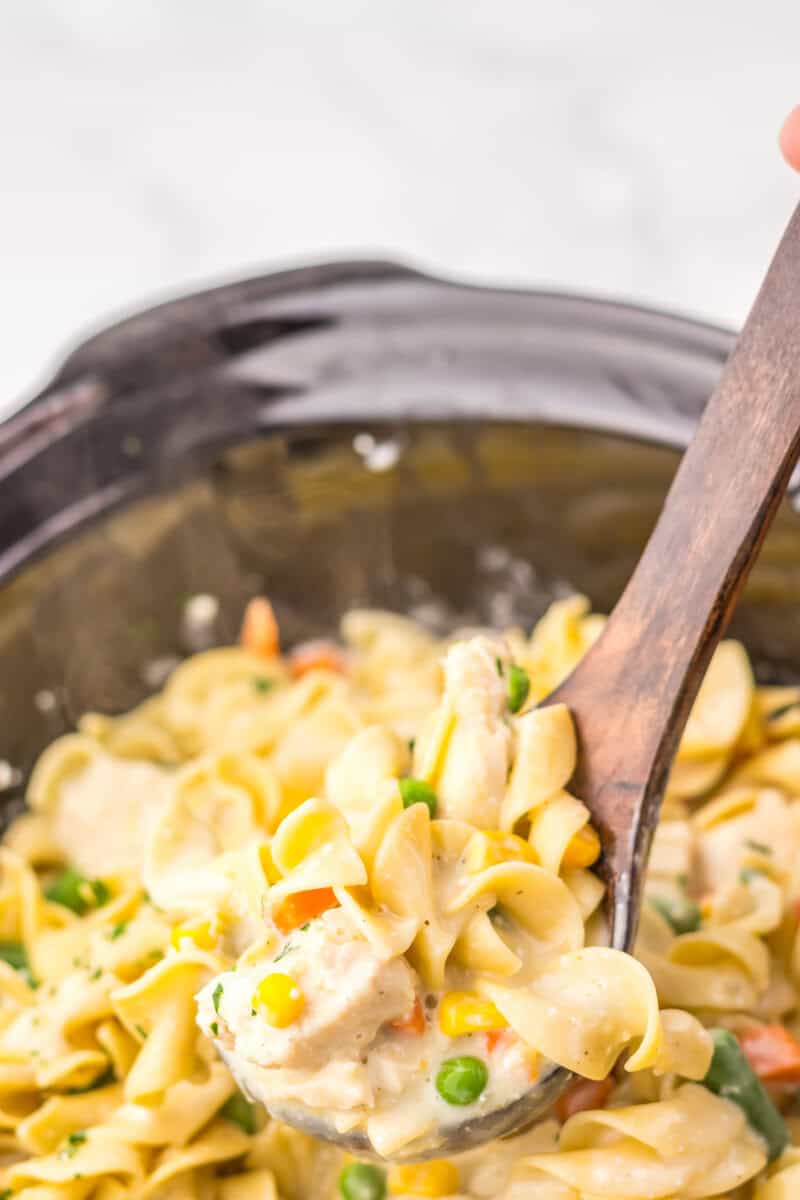 Stirring the egg noodles together with the rich creamy sauce.