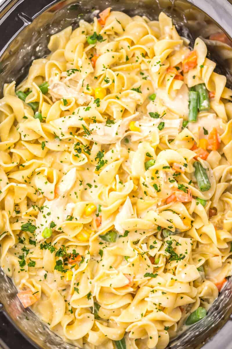 Adding the parsley to the egg noodle mixture.