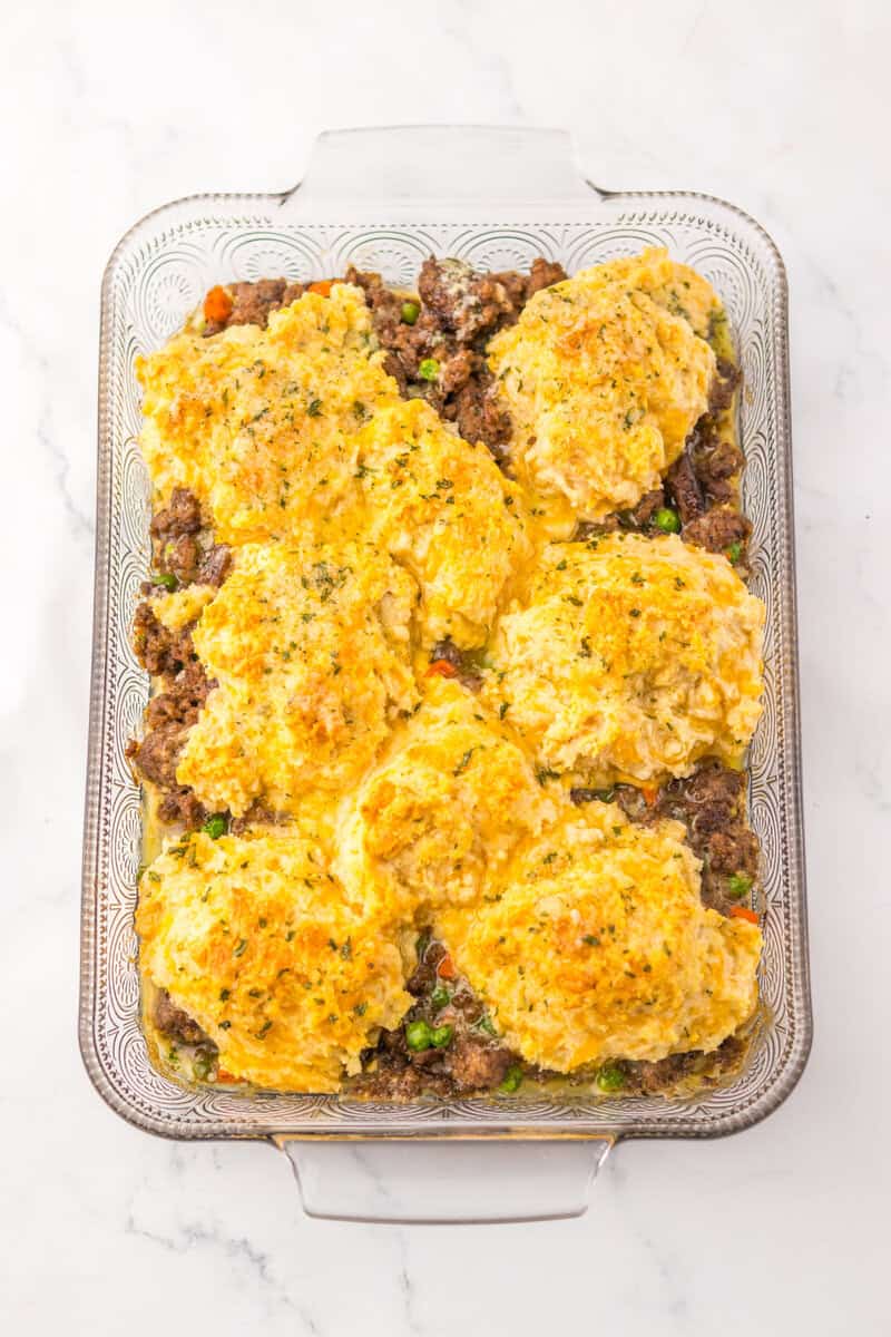 Ground beef cobbler in a clear glass baking dish topped with Cheddar Bay Biscuits.