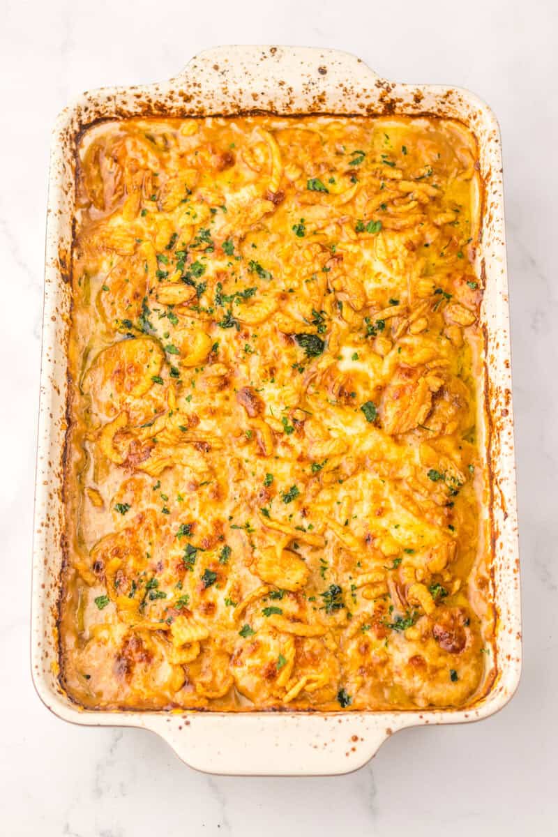A French onion potato bake in a white ceramic baking dish.