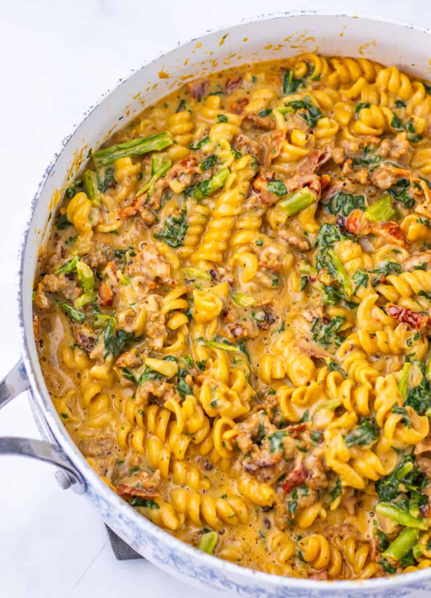 A pot of creamy Tuscan chicken pasta with Rotini.