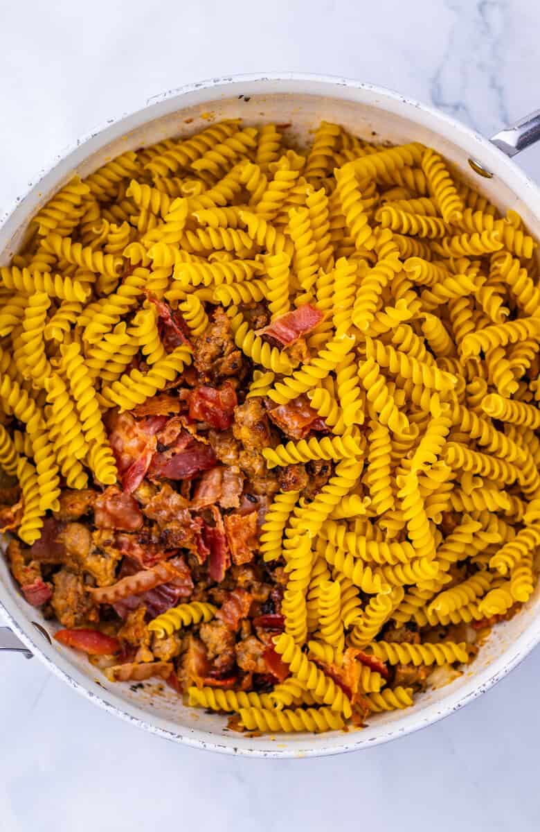 Sundried tomatoes and dried rotini pasta in a Dutch oven.