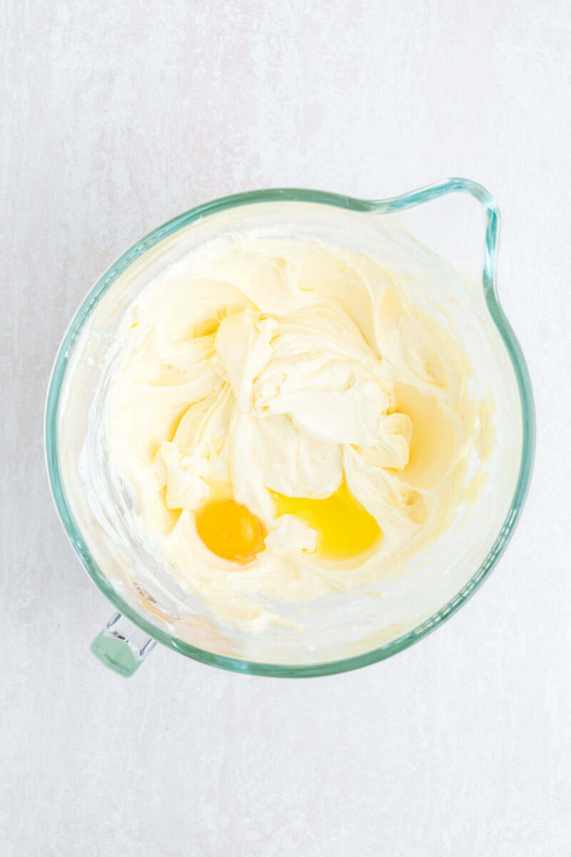 Cheesecake filling in a large glass measuring cup.