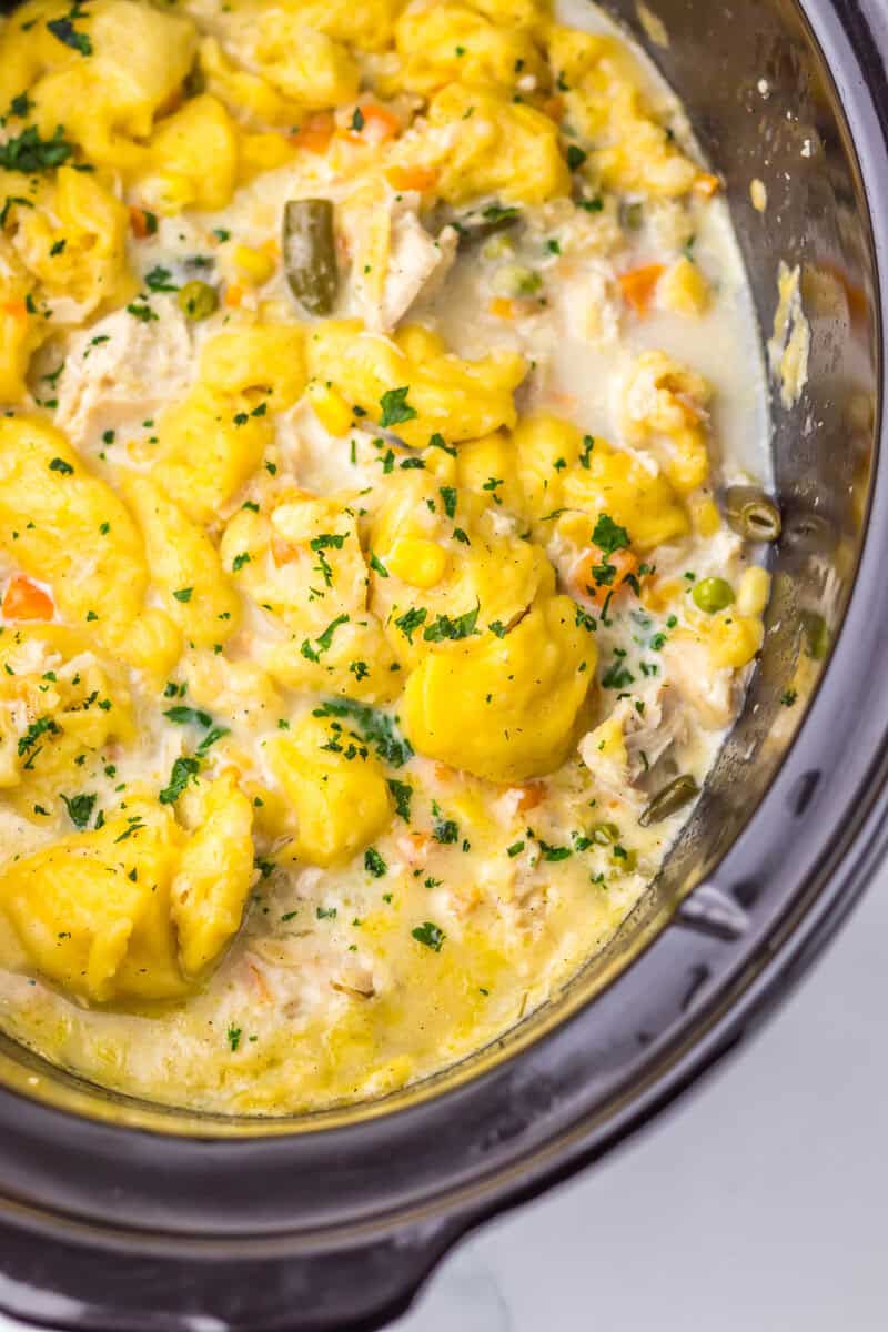 A black crock pot filled with chicken pot pie and dumplings.