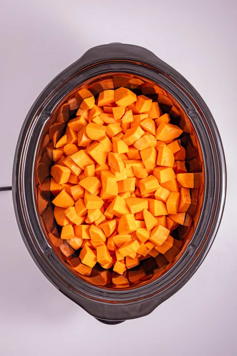 Diced sweet potatoes in a slow cooker.